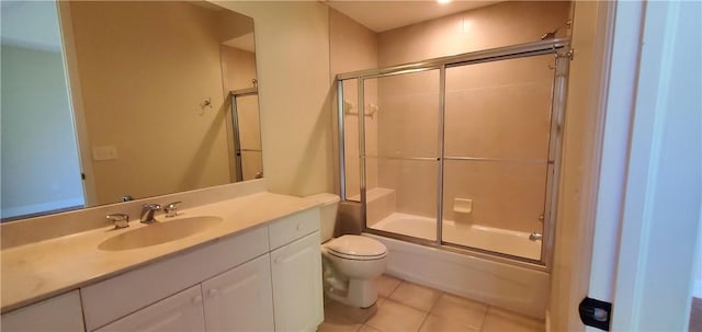 full bathroom with toilet, bath / shower combo with glass door, tile patterned flooring, and vanity