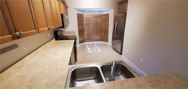 kitchen with light tile patterned floors, sink, and appliances with stainless steel finishes