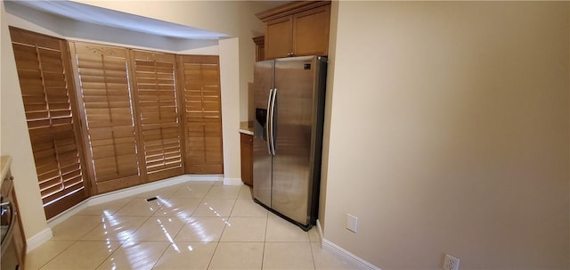 kitchen with stainless steel fridge with ice dispenser and light tile patterned floors