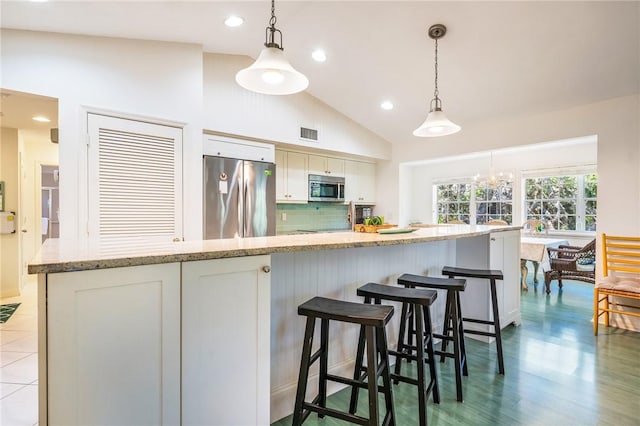 1295 Winding Oaks Cir E Unit 805, Vero Beach, FL 32963 - kitchen featuring appliances with stainless steel finishes, white cabinets, decorative light fixtures, decorative backsplash, and recessed lighting