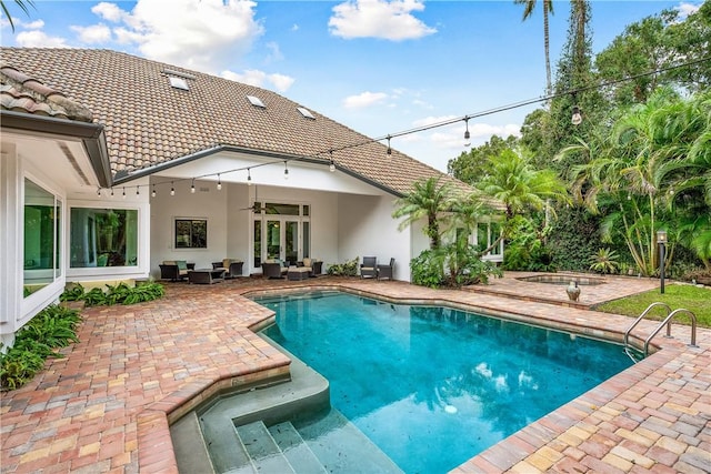 pool with a patio, outdoor lounge area, a ceiling fan, and a hot tub