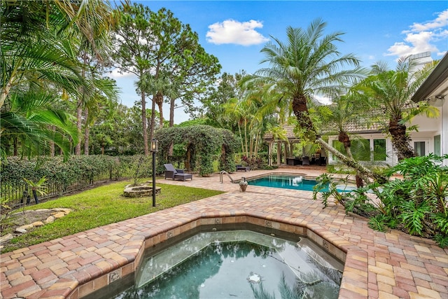 view of pool with a fenced in pool, a patio, fence, an in ground hot tub, and a fire pit