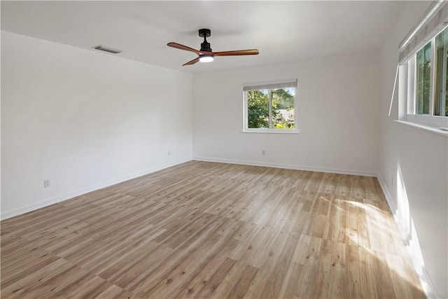 unfurnished room featuring visible vents, baseboards, a ceiling fan, and light wood finished floors