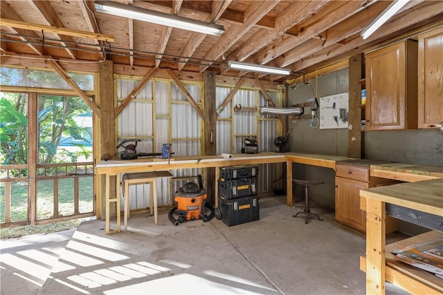 misc room with unfinished concrete flooring and a workshop area