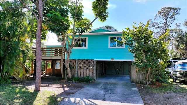 coastal home featuring a carport, stairway, and driveway