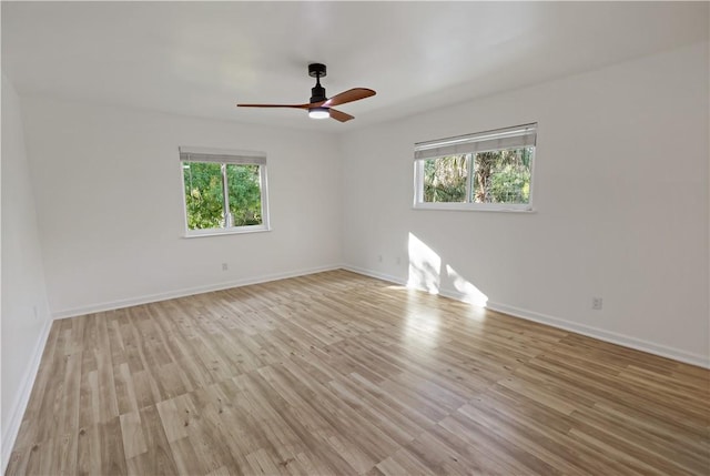 unfurnished room with baseboards, light wood-type flooring, a wealth of natural light, and ceiling fan