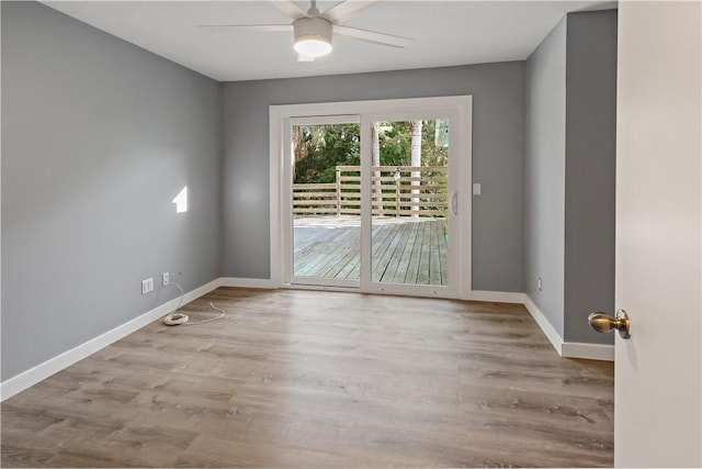 unfurnished room with a ceiling fan, wood finished floors, and baseboards