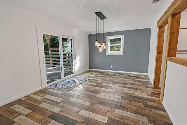 unfurnished dining area featuring a textured ceiling, baseboards, an inviting chandelier, and wood finished floors