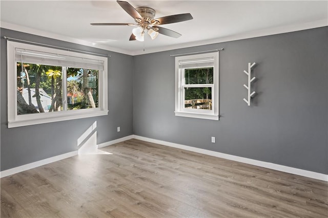 empty room featuring baseboards, plenty of natural light, and ceiling fan