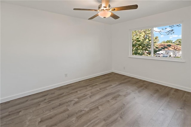 unfurnished room with ceiling fan, baseboards, and wood finished floors