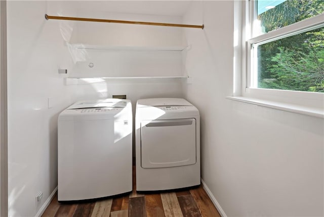 clothes washing area with dark wood-style floors, laundry area, baseboards, and separate washer and dryer