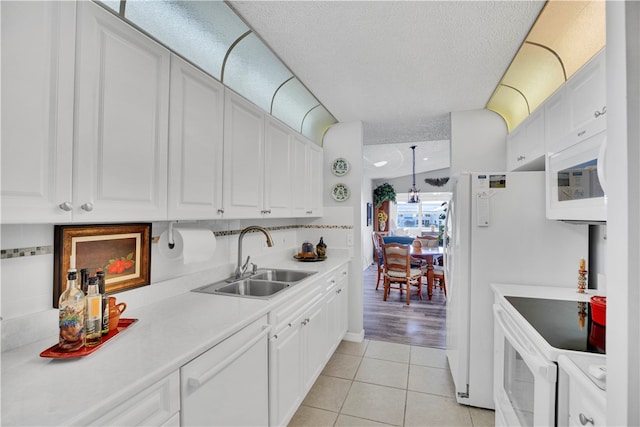 kitchen with white cabinets, white appliances, sink, and decorative backsplash