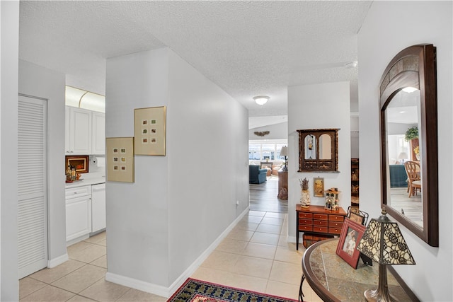 hallway featuring a textured ceiling and light tile patterned flooring