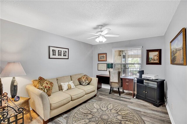 500 Grove Isle Cir Unit 202, Vero Beach, FL 32962 - living room featuring light wood-style flooring, a textured ceiling, a ceiling fan, an office area, and baseboards