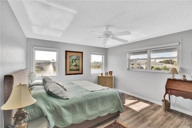 500 Grove Isle Cir Unit 202, Vero Beach, FL 32962 - bedroom featuring a textured ceiling, baseboards, wood finished floors, and ceiling fan