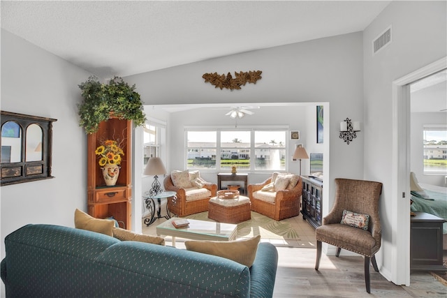 living room with plenty of natural light, light wood-type flooring, and lofted ceiling