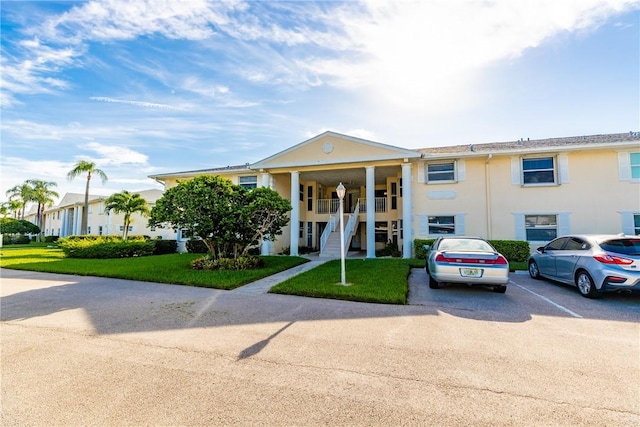 500 Grove Isle Cir Unit 202, Vero Beach, FL 32962 - greek revival inspired property with stairway, uncovered parking, a front lawn, and a porch