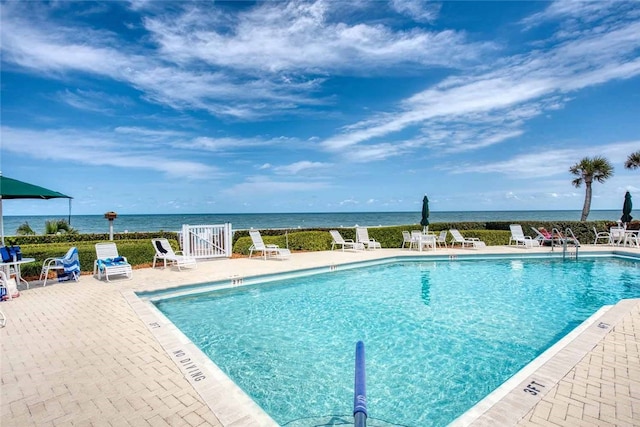 view of swimming pool with a patio and a water view