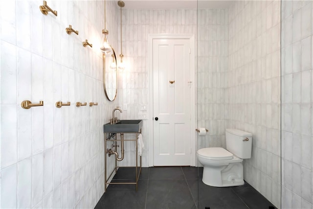 bathroom featuring toilet, tile walls, sink, and tile patterned flooring