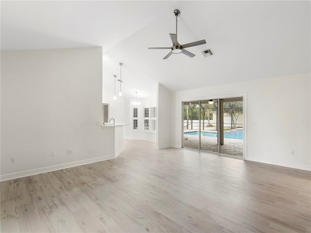 unfurnished living room with light wood-type flooring, ceiling fan, sink, and high vaulted ceiling