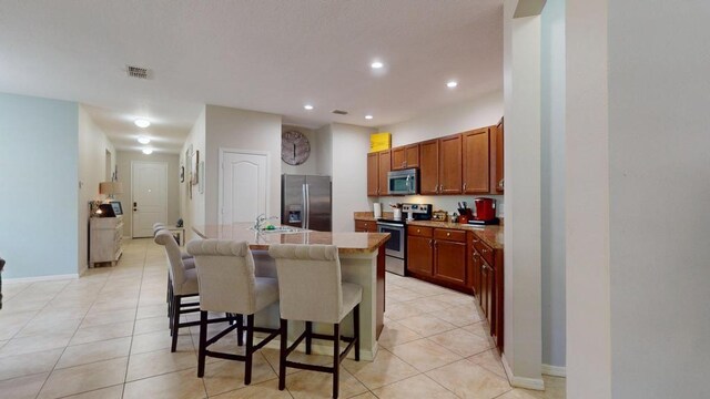 138 Port Royal Ct, Sebastian, FL 32958 - kitchen featuring appliances with stainless steel finishes, light tile patterned flooring, a kitchen island with sink, light countertops, and recessed lighting