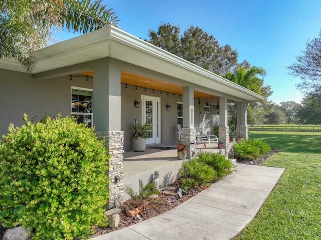 property entrance with ceiling fan and a lawn