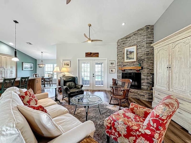 living room with french doors, vaulted ceiling, dark hardwood / wood-style floors, ceiling fan, and a fireplace