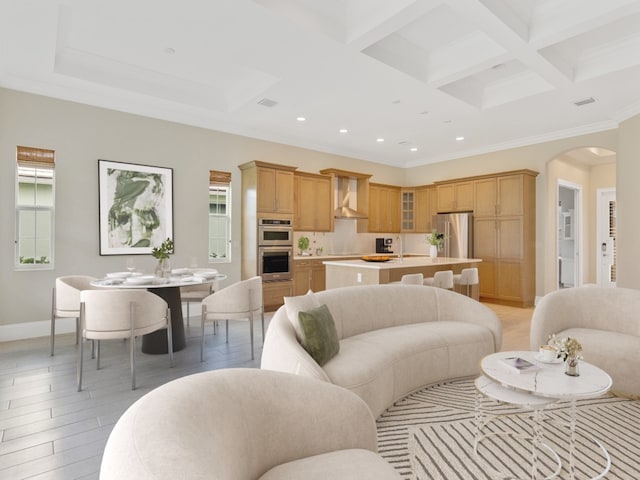 living room with light hardwood / wood-style flooring, beamed ceiling, crown molding, and coffered ceiling