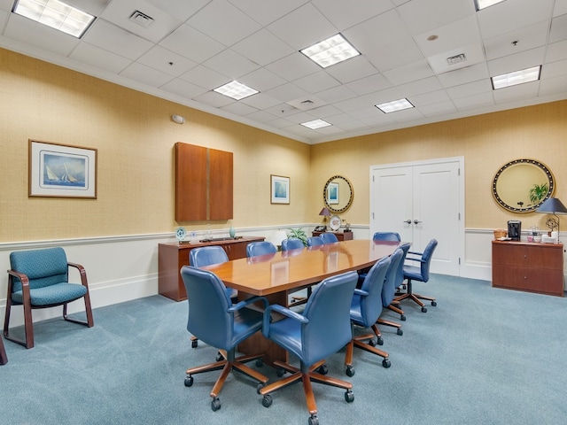 office space with a drop ceiling, light carpet, and crown molding