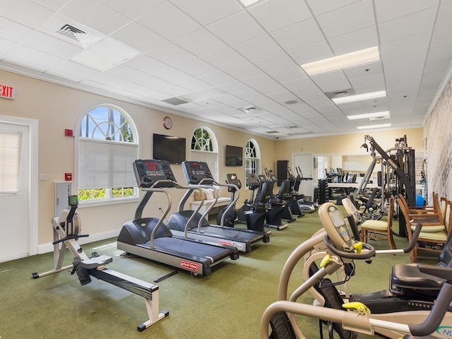 workout area featuring a paneled ceiling and crown molding