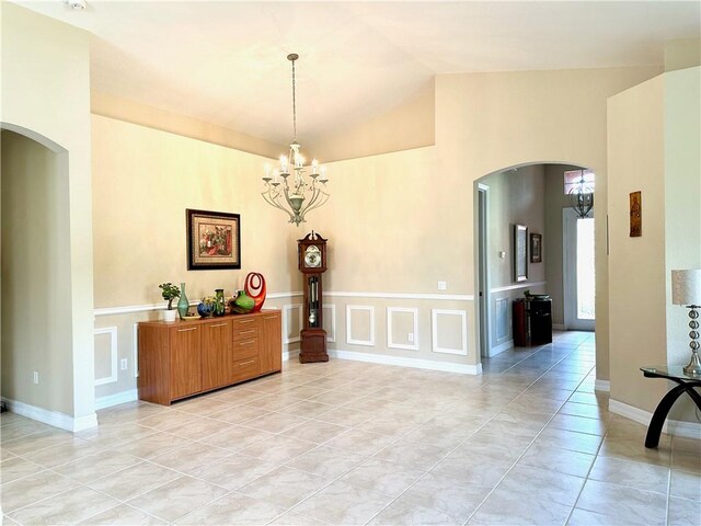 tiled living room with vaulted ceiling and a chandelier