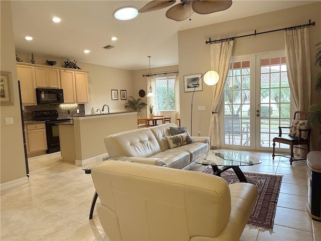 living room featuring light tile patterned floors, french doors, and ceiling fan