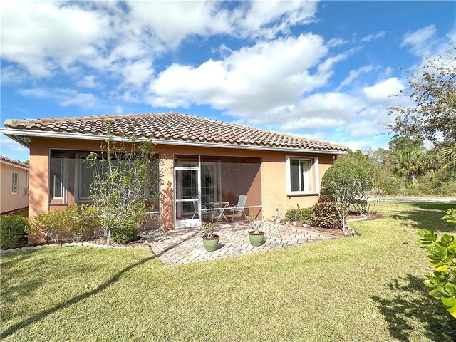 rear view of property featuring a yard and a patio