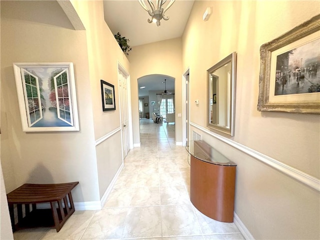 corridor with baseboards and arched walkways