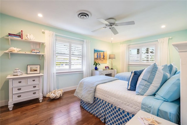 bedroom featuring visible vents, multiple windows, baseboards, and wood finished floors