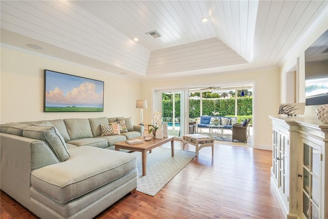 living room featuring wood finished floors, wood ceiling, a tray ceiling, and ornamental molding