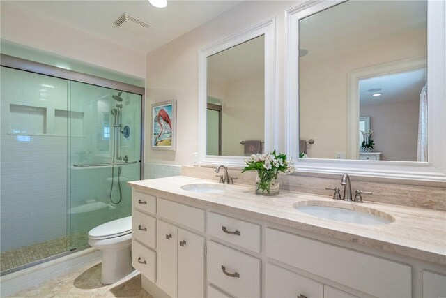 bathroom featuring visible vents, a shower stall, toilet, and a sink