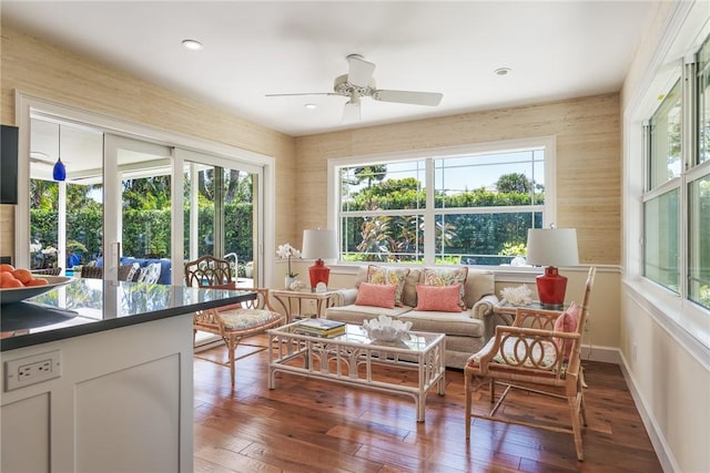 living area with a wealth of natural light, wood-type flooring, and ceiling fan