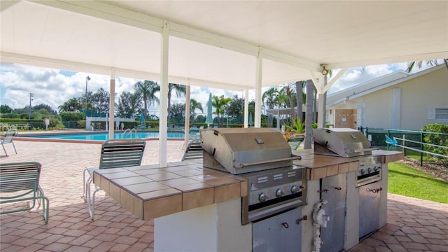 view of patio / terrace featuring a fenced in pool and area for grilling