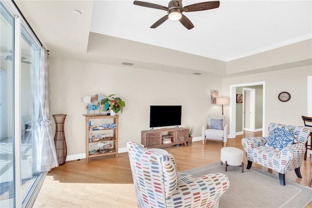 living room with light wood-style floors, visible vents, and baseboards