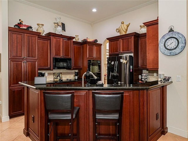 kitchen with light tile patterned flooring, dark brown cabinets, and black appliances