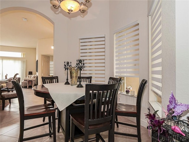 dining room featuring arched walkways and tile patterned floors