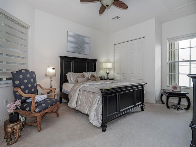 bedroom with light colored carpet, a closet, visible vents, and multiple windows