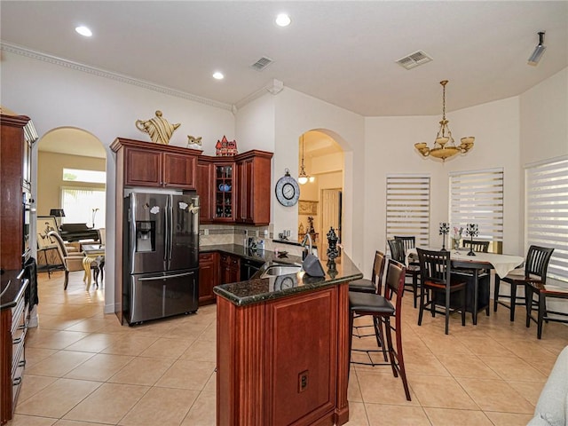 kitchen featuring arched walkways, stainless steel appliances, a sink, and visible vents