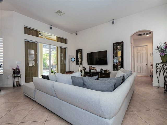 living area featuring visible vents, arched walkways, and light tile patterned flooring