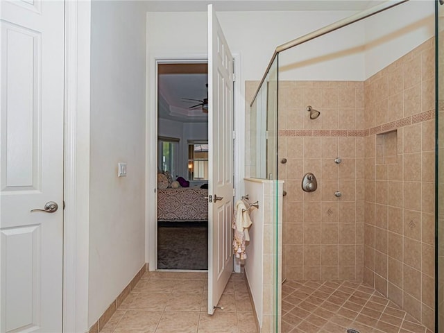 ensuite bathroom featuring a ceiling fan, a stall shower, connected bathroom, baseboards, and tile patterned floors