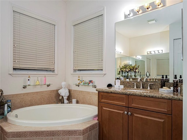 bathroom with a garden tub and vanity