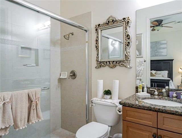 bathroom with toilet, a ceiling fan, a stall shower, vanity, and ensuite bath