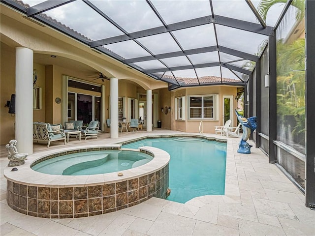 view of pool featuring a patio, ceiling fan, a lanai, a pool with connected hot tub, and an outdoor living space