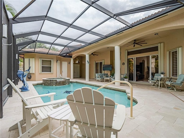 view of pool with a patio, glass enclosure, an outdoor hangout area, a pool with connected hot tub, and a ceiling fan